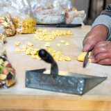 Vediamo la donna prendere un panetto di massa dato dall�impasto di semola di grano duro e acqua...